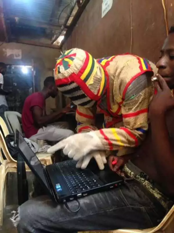 Photos: Nigerian Masquerade Spotted Seriously Chatting Online With A Computer